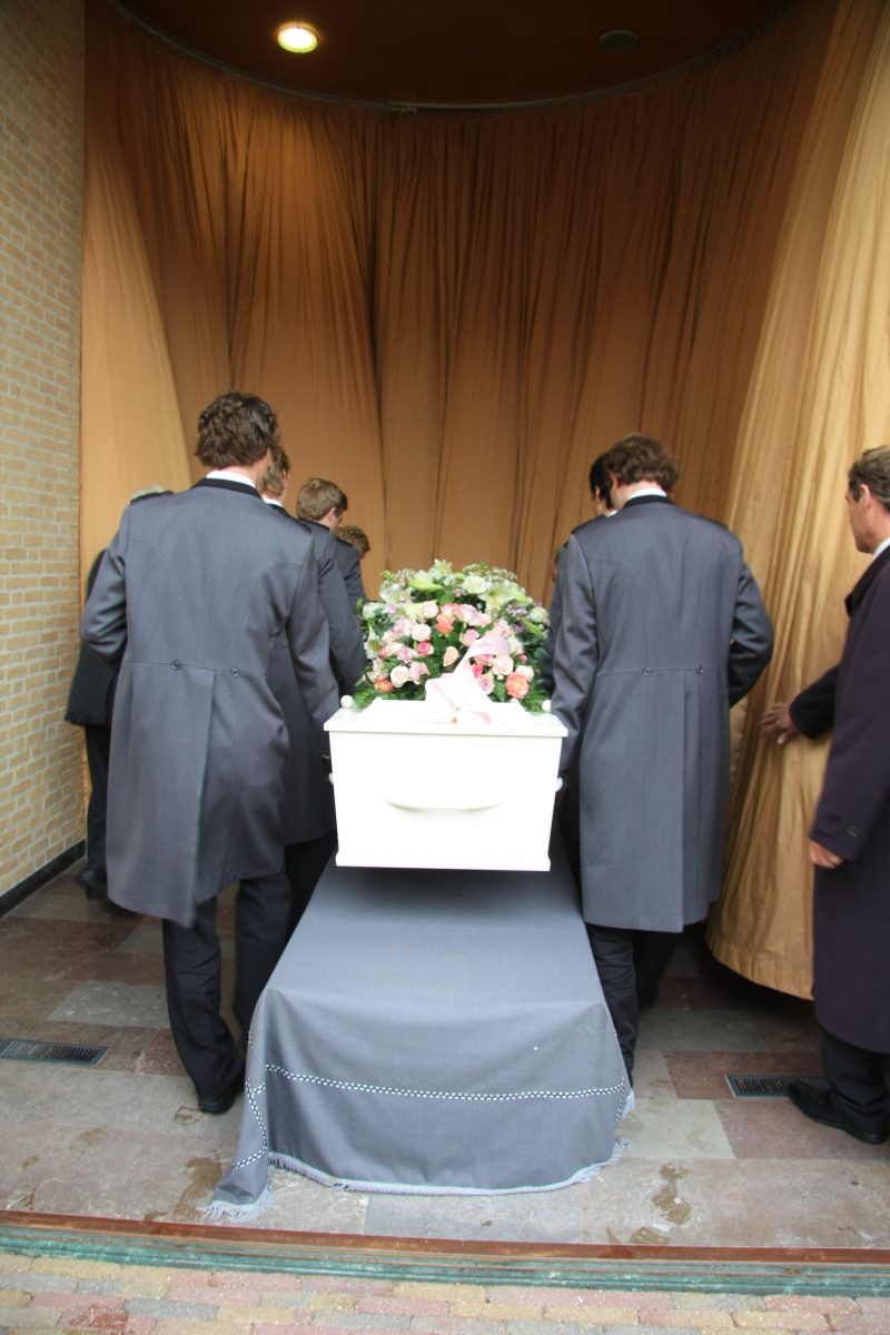11194230_xl-Funeral home employees preparing a casket for a funeral service