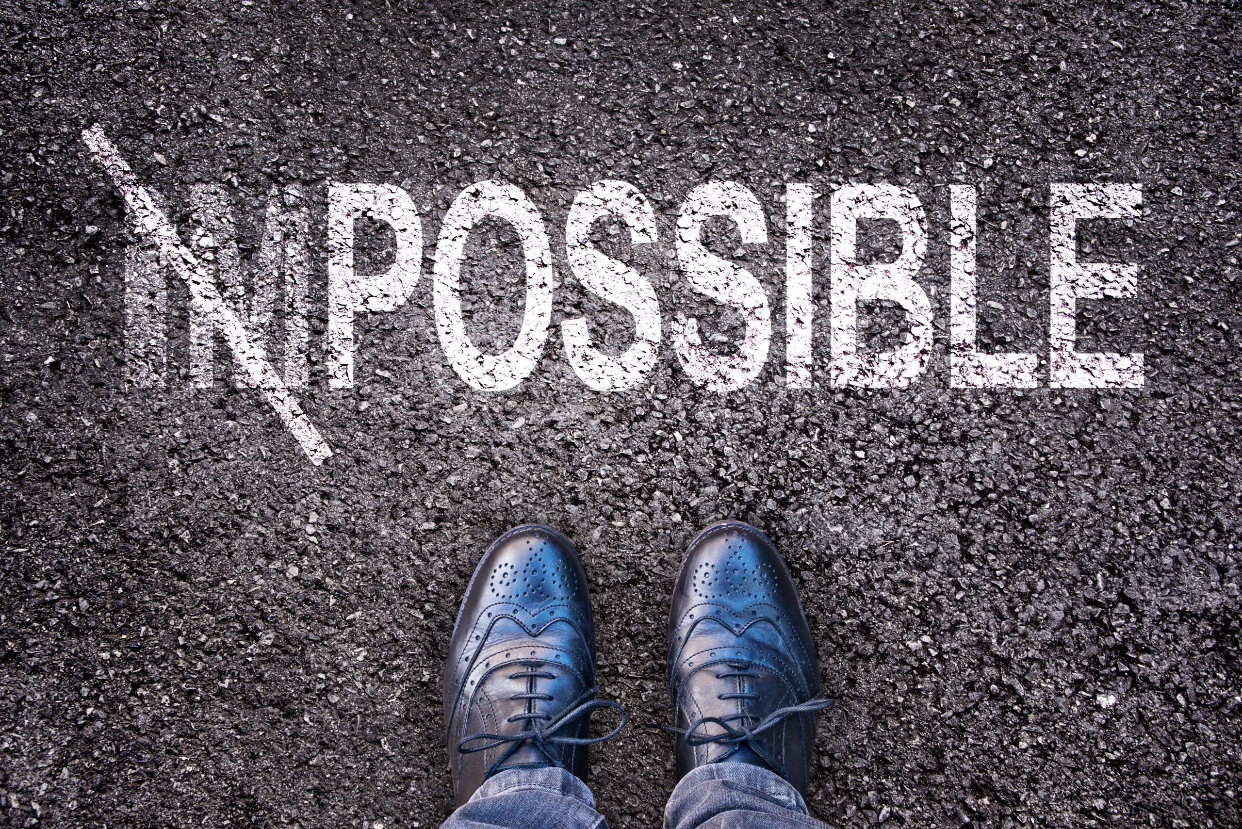 Changing the word impossible on possible on an asphalt road with feet