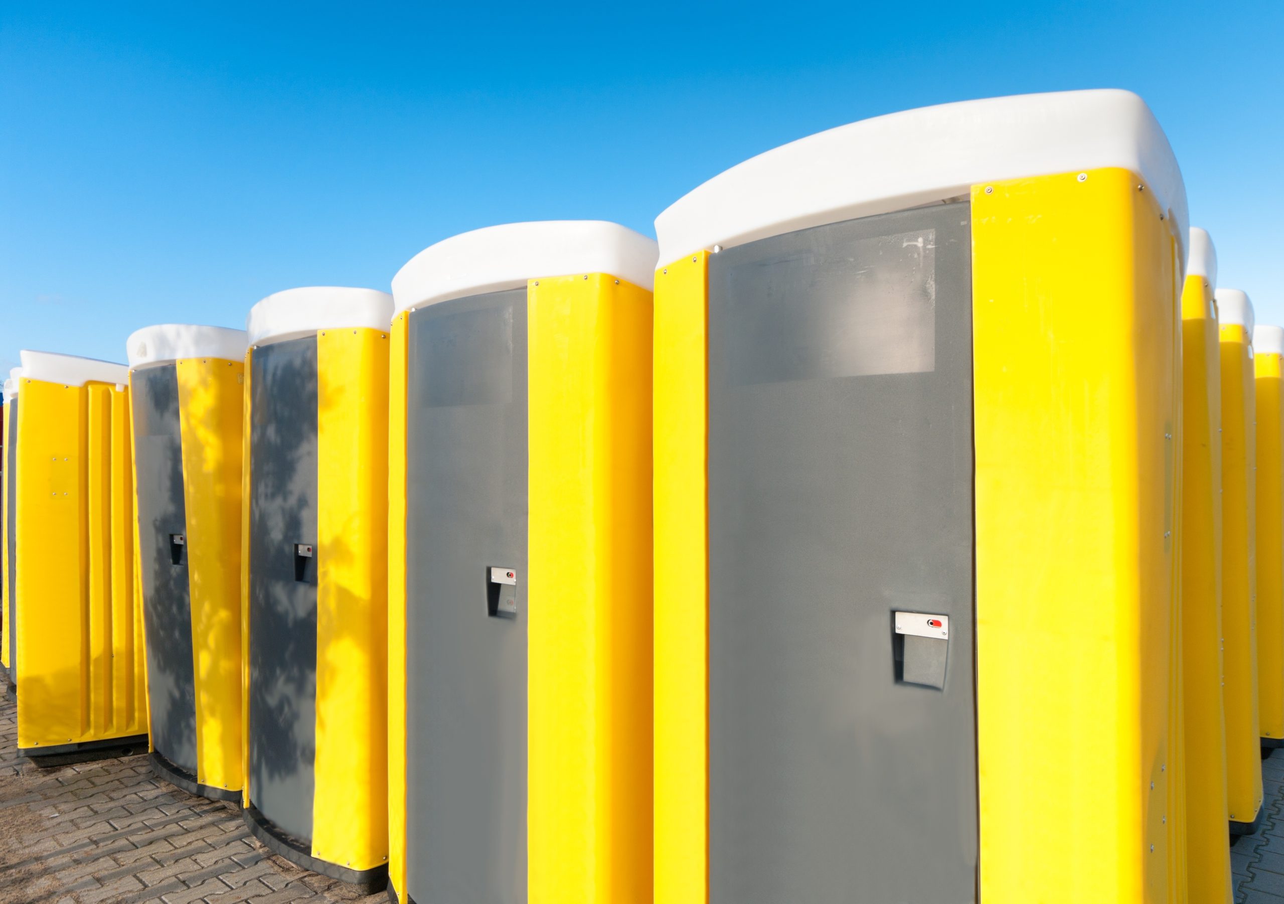 12323805 – yellow portable toilets under a nice cloudy sky