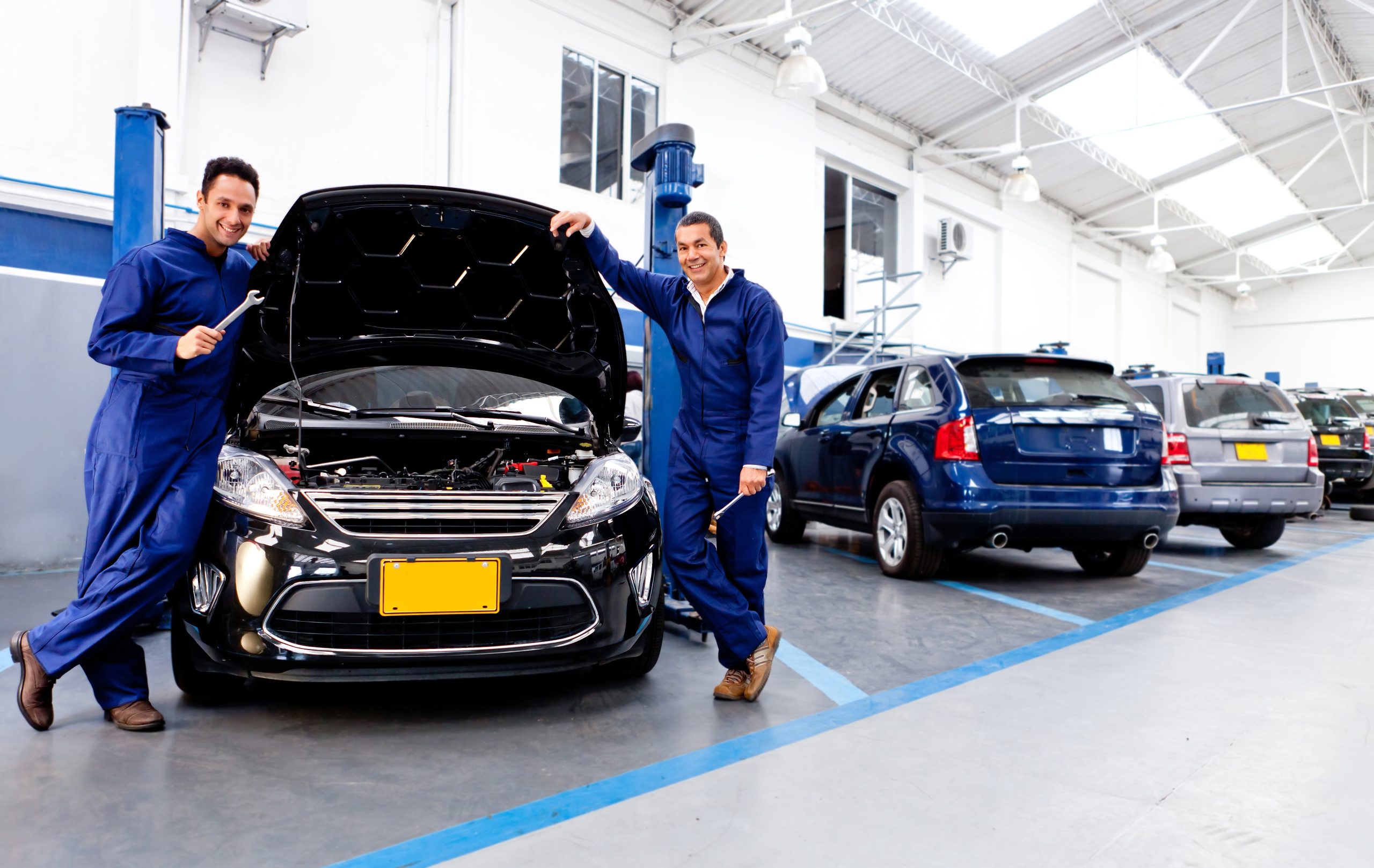 12824417 – car mechanics smiling at the auto repair shop