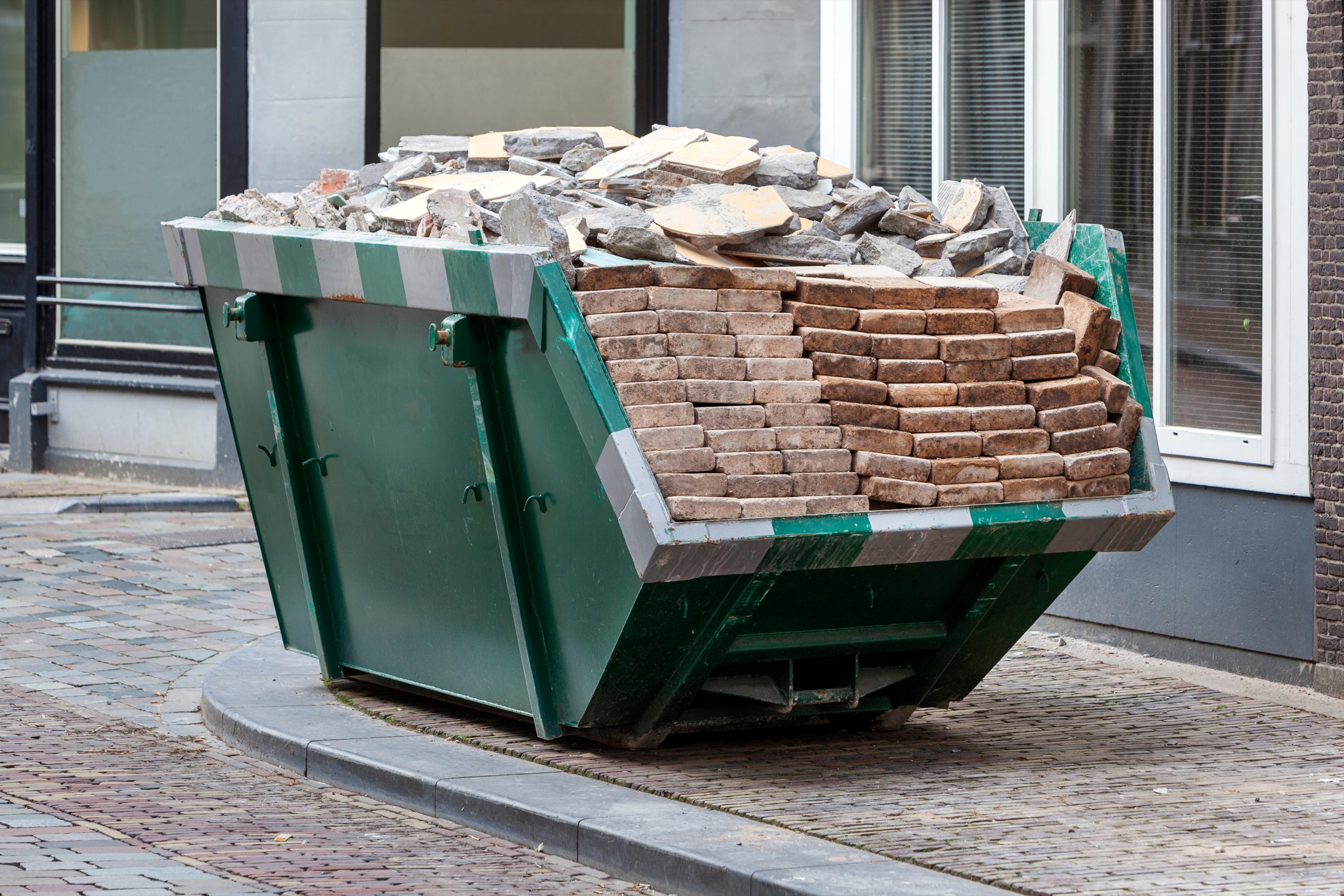 Neat industrial skip full loaded with bricks and rubble